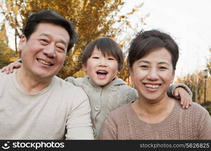 Portrait of Grandparents and Grandson in the Park