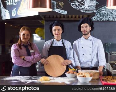 Portrait of group chefs standing together in commercial kitchen at restaurant. Portrait of group chefs