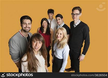 Portrait of group of friends standing together over colored background