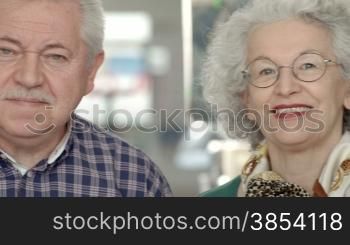 Portrait of group of happy old men and women looking at camera and smiling in library
