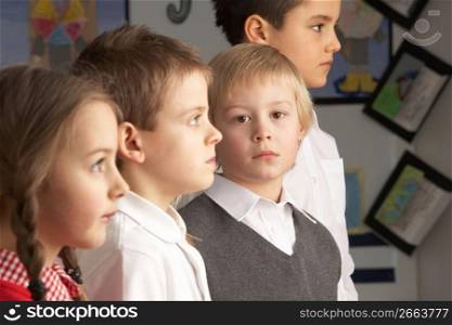 Portrait Of Group Of Primary Schoolchildren Standing In Classroom