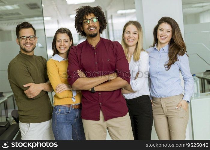 Portrait of group of young excited business people standing in office