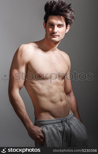 Portrait of half naked sexy body of muscular athletic man. Studio shot
