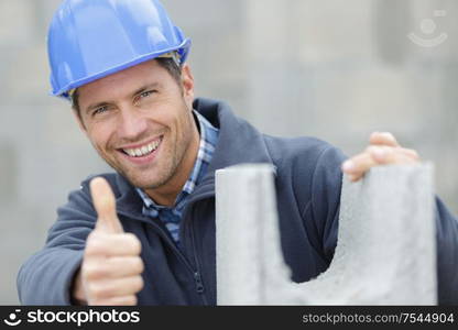 portrait of handsome builder showing thumbs up