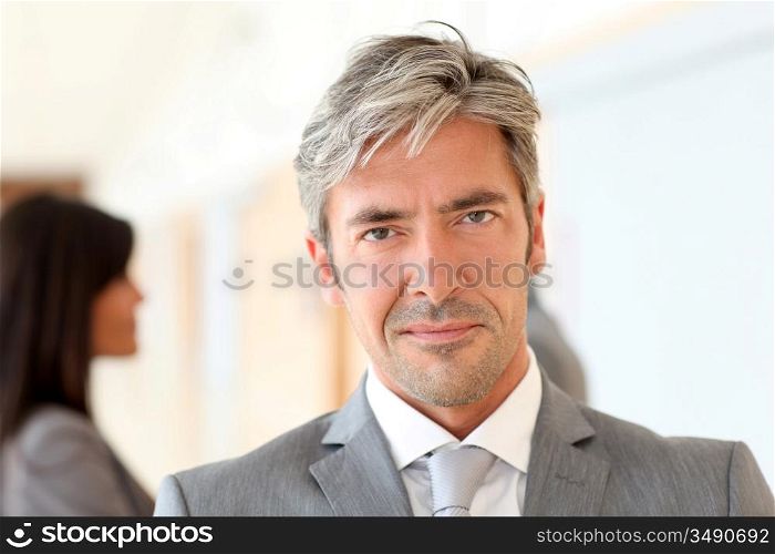 Portrait of handsome businessman standing in hall