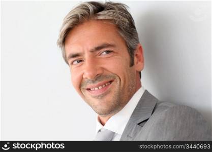 Portrait of handsome businessman standing on grey background