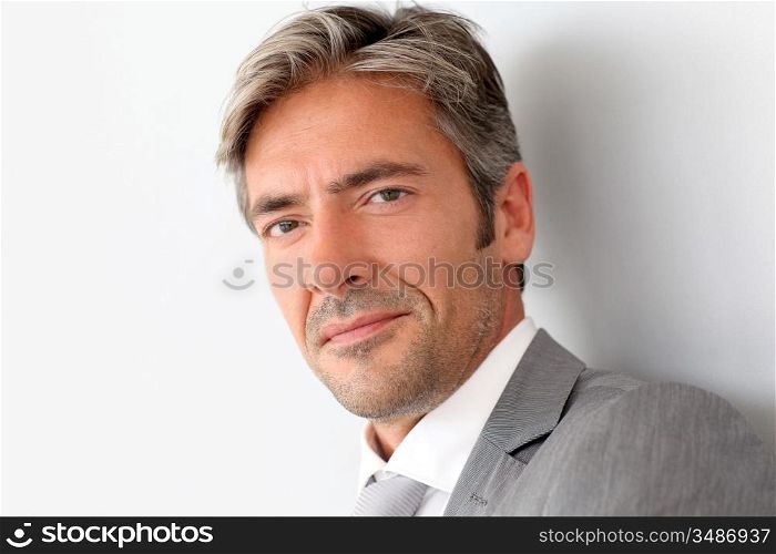 Portrait of handsome businessman standing on grey background