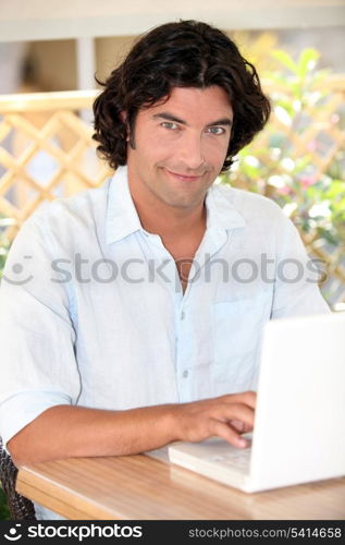 portrait of handsome dark-haired man working on laptop