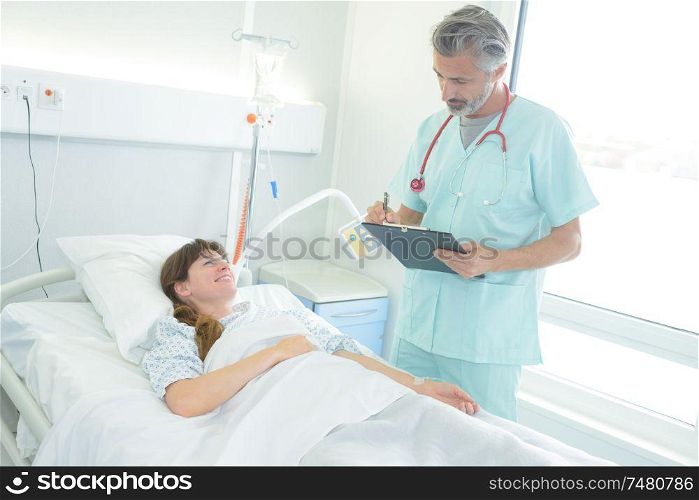 portrait of handsome doctor and smiling pretty patient in hospital