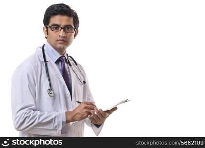 Portrait of handsome doctor writing on clipboard
