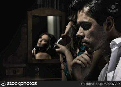 Portrait of handsome man and pretty girl doing make up
