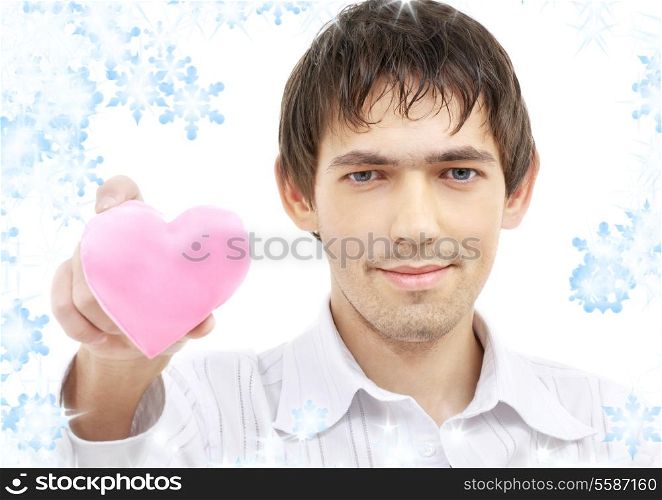 portrait of handsome man giving pink heart-shaped pillow