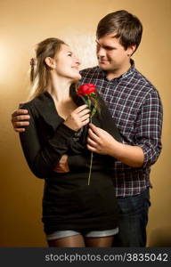 Portrait of handsome man giving red rose to girlfriend