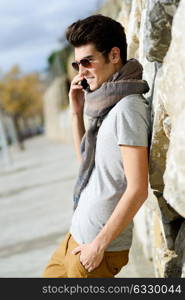 Portrait of handsome man in urban background talking on phone