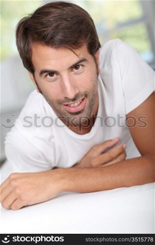 Portrait of handsome man relaxing on bed