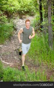Portrait of handsome man running in forest against blur background