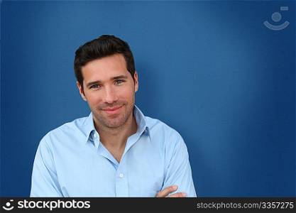 Portrait of handsome man standing on blue background