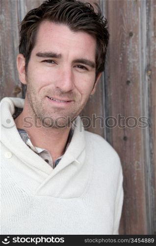 Portrait of handsome man standing on wooden door