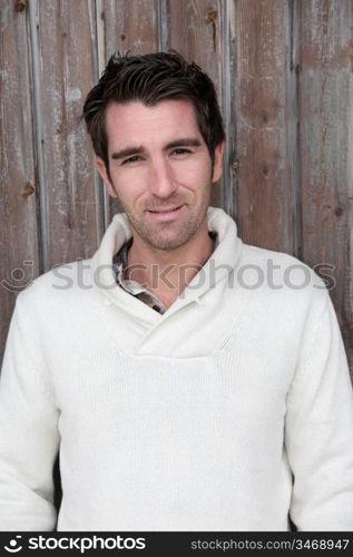 Portrait of handsome man standing on wooden door