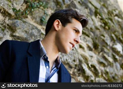 Portrait of handsome man with modern hairstyle in urban background
