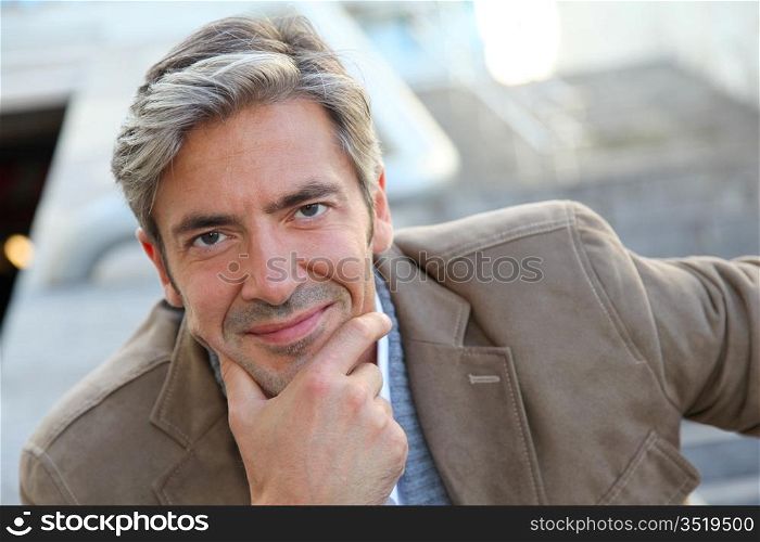 Portrait of handsome mature man in town