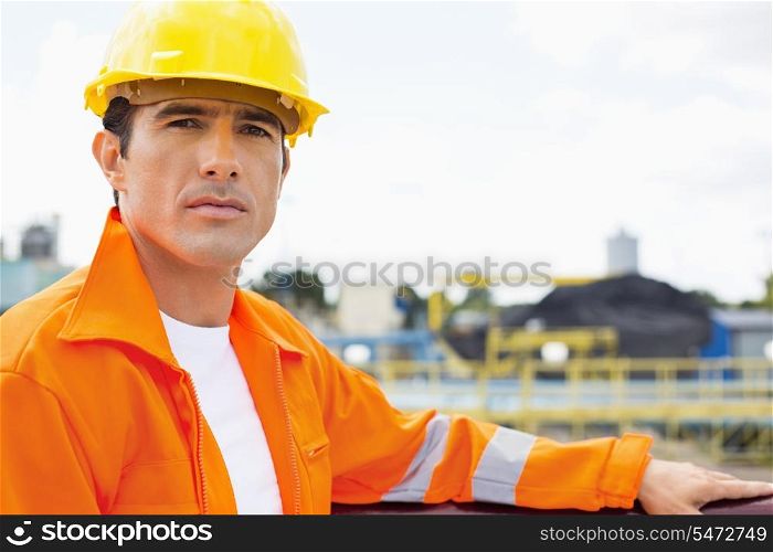 Portrait of handsome mid adult man wearing protective workwear at construction site