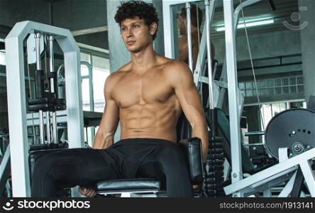 Portrait of handsome muscular caucasian man is doing exercise in gym. Healthy, Sport and Lifestyle concept.