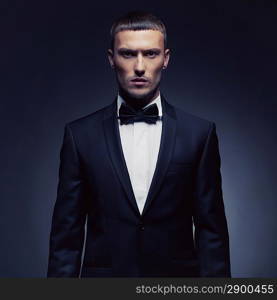 Portrait of handsome stylish man in elegant black suit