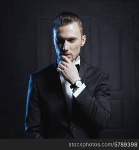 Portrait of handsome stylish man in elegant black suit