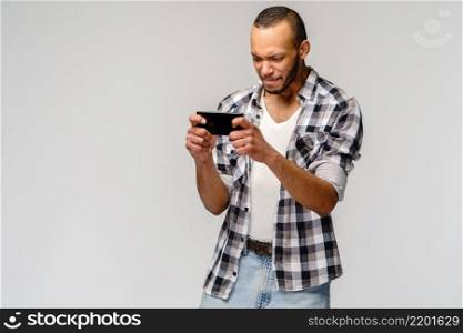 portrait of handsome young african-american man shocked with mouth open mad by what he sees on his cell phone.. portrait of handsome young african-american man shocked with mouth open mad by what he sees on his cell phone