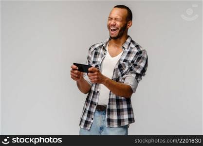 portrait of handsome young african-american man shocked with mouth open mad by what he sees on his cell phone.. portrait of handsome young african-american man shocked with mouth open mad by what he sees on his cell phone