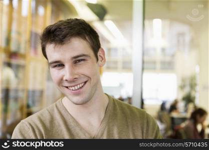Portrait of handsome young businessman smiling in office