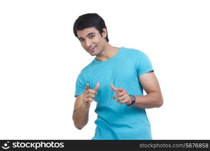 Portrait of handsome young man pointing towards you over white background