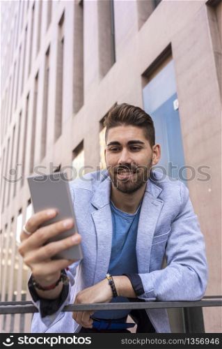 Portrait of Handsome young man smiling when he is using his mobile phone