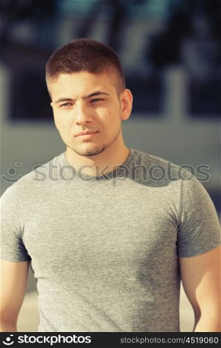 Portrait of handsome young muscular man in urban context