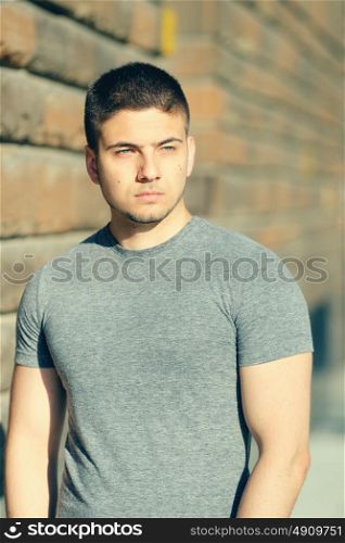 Portrait of handsome young muscular man in urban context