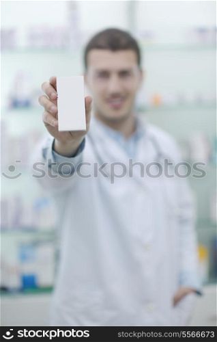 portrait of handsome young pharmacist chemist man standing in pharmacy drugstore