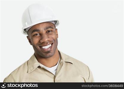 Portrait of happy African construction over with hardhat over gray background