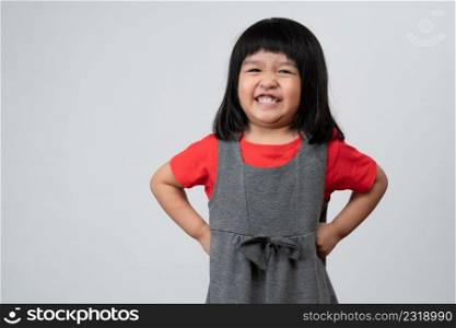 Portrait of happy and funny Asian child girl on white background, a child looking at camera. Preschool kid dreaming fill with energy feeling healthy and good concept