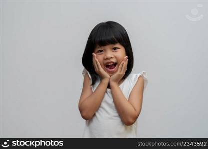 Portrait of happy and funny Asian child girl on white background, a child looking at camera. Preschool kid dreaming fill with energy feeling healthy and good concept