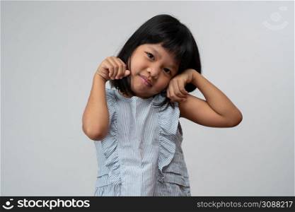 Portrait of happy and funny Asian child girl on white background, a child looking at camera hand gesture. Preschool kid dreaming fill with energy feeling healthy and good concept