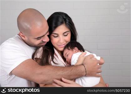 Portrait of happy arabic family at home, young parents holding on hands little sweet newborn baby, love and happiness concept