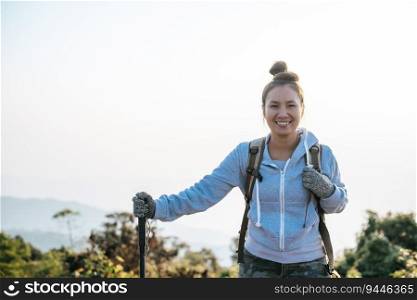 Portrait of Happy Asian hiker woman with backpack looking at camera on mountain with copy space. Travel Lifestyle wanderlust adventure concept vacations outdoor.