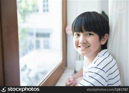 Portrait of happy asian school child boy smile in first day of back to school,Intelligent smart boy standing face to window in classroom at primary school .