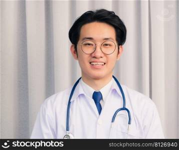 Portrait of Happy Asian young doctor handsome man smiling in uniform with stethoscope talking online video conference call or facetime looking to camera, healthcare medicine concept