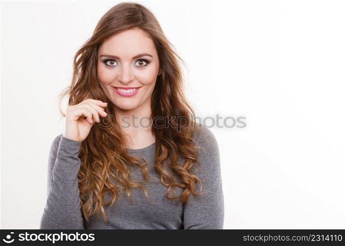 Portrait of happy attractive woman having long brown curly hair wearing grey top. Portrait of happy attractive woman wearing grey top
