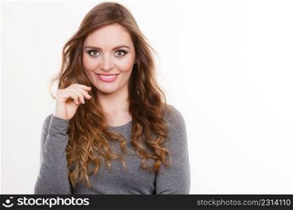 Portrait of happy attractive woman having long brown curly hair wearing grey top. Portrait of happy attractive woman wearing grey top