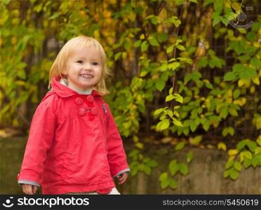 Portrait of happy baby in red coat outdoors
