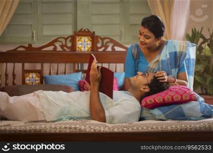 Portrait of happy Bengali couple in bedroom