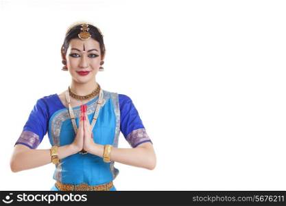 Portrait of happy Bharatanatyam dancer in prayer position over white background